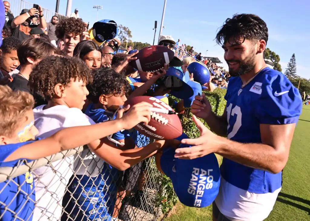 Rams wide receiver Puka Nacua signs autograhs the first day...