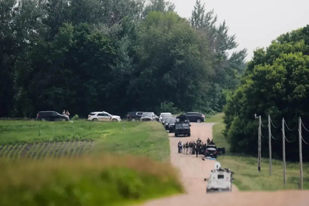 Members of law enforcement agencies investigate near a vehicle suspected to belong to Vance Boelter.