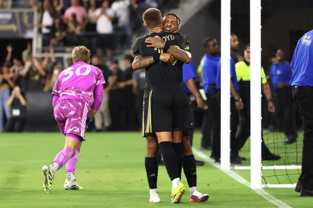 Los Angeles FC forward Denis Bouanga, back, hugs teammate forward...