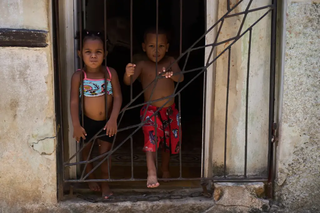 Children cool off in their doorway during a blackout in...