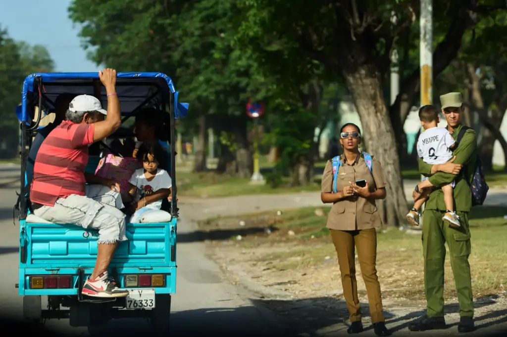 People ride in an electric tricycle in Havana, Cuba, Friday,...