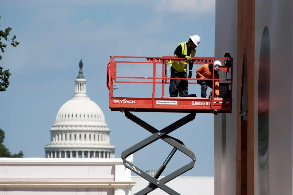 Workers work on a State’s pavilion for the Great American...