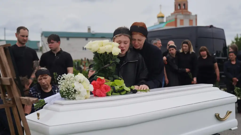 People mourn over the coffin of Oleksandra Bardadym.