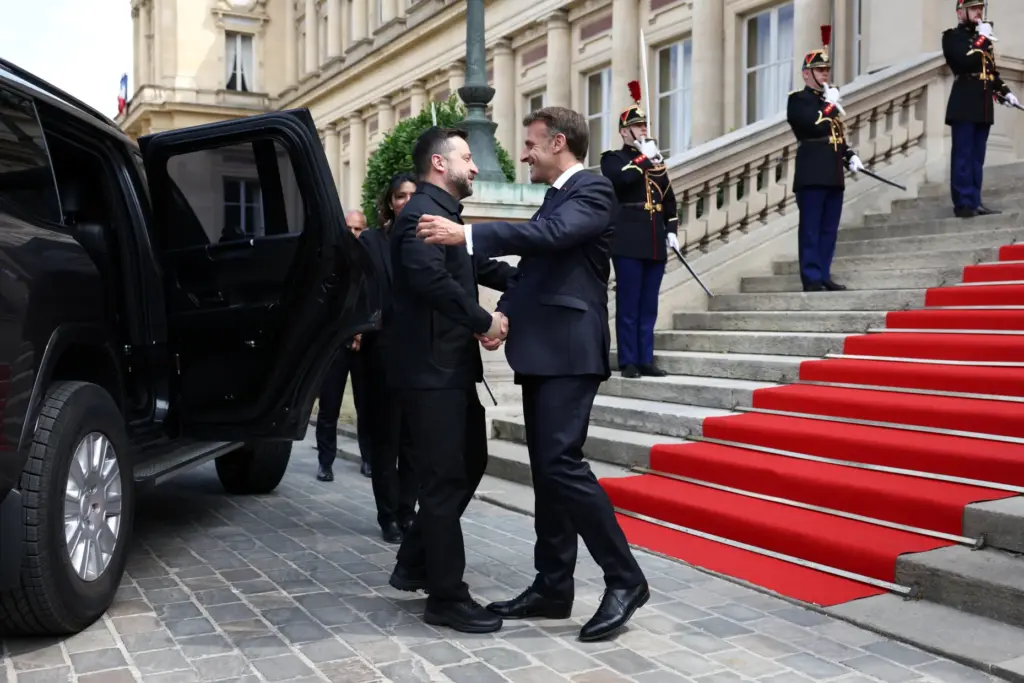 French President Emmanuel Macron, right, shakes hands with Ukrainian President...