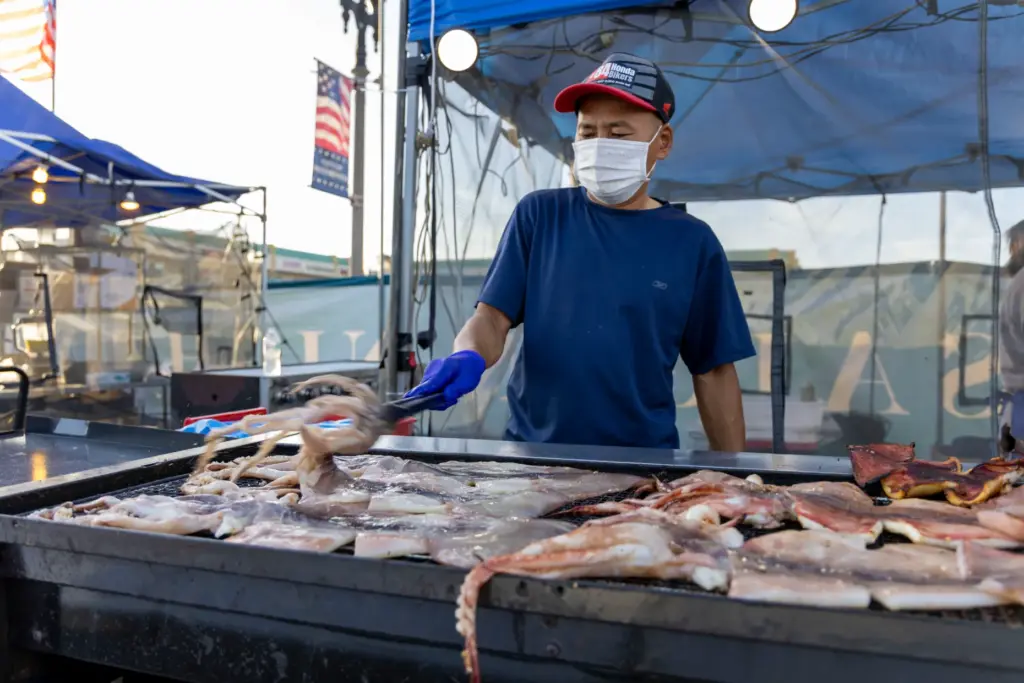 Hieu Mai flips and grills squid at the Má»±c NÆ°á»ng...