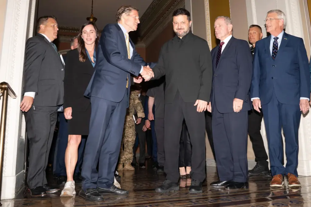 Ukraine's President Volodymyr Zelenskyy stands with a bipartisan group of senators in the Capitol.