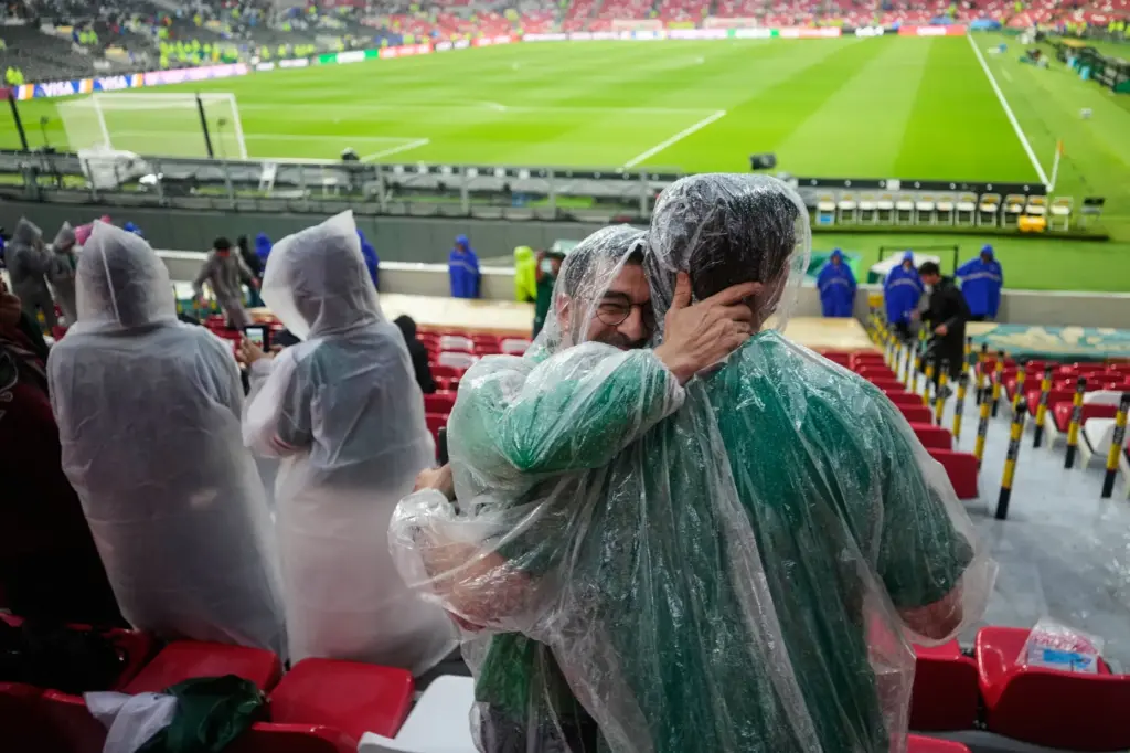 Fans wear ponchos as it rains ahead of the World...