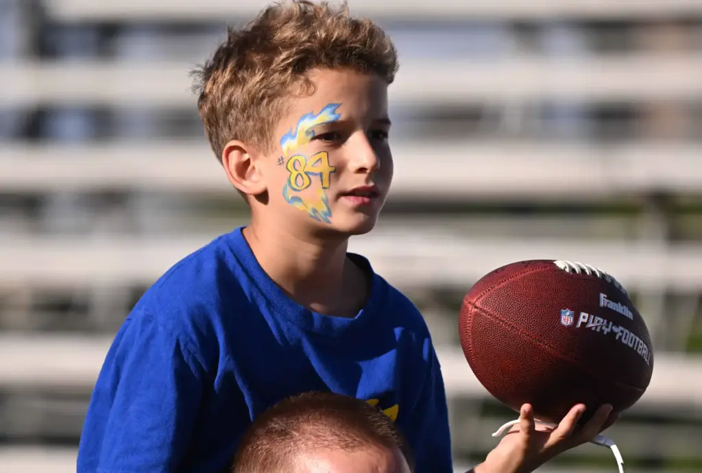 A young fan waits for an autogrph from Rams tight...