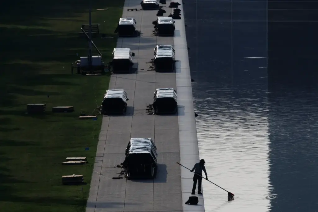 A worker clears debris from the Lincoln Memorial Reflecting Pool,...
