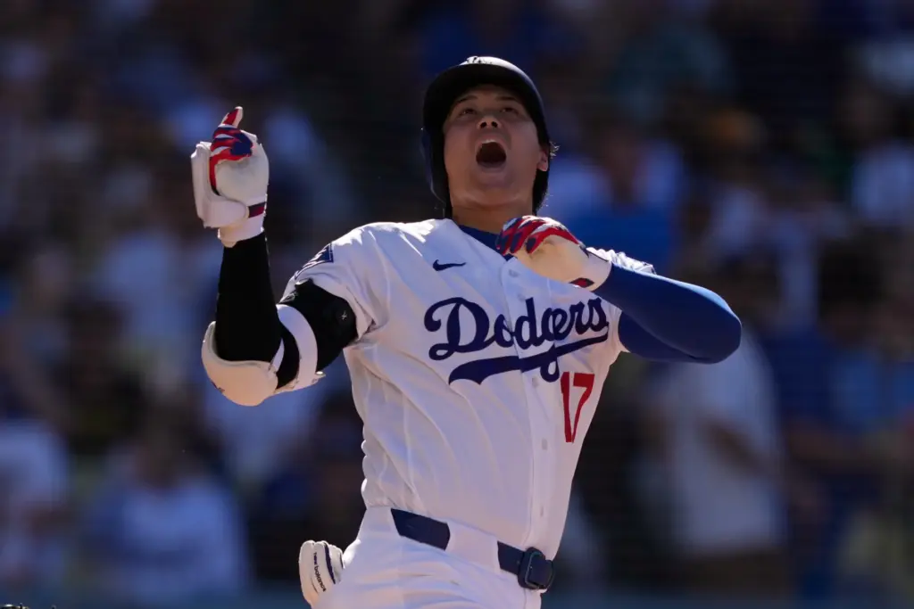 Dodgers’ Shohei Ohtani yells as he loses his bat during...