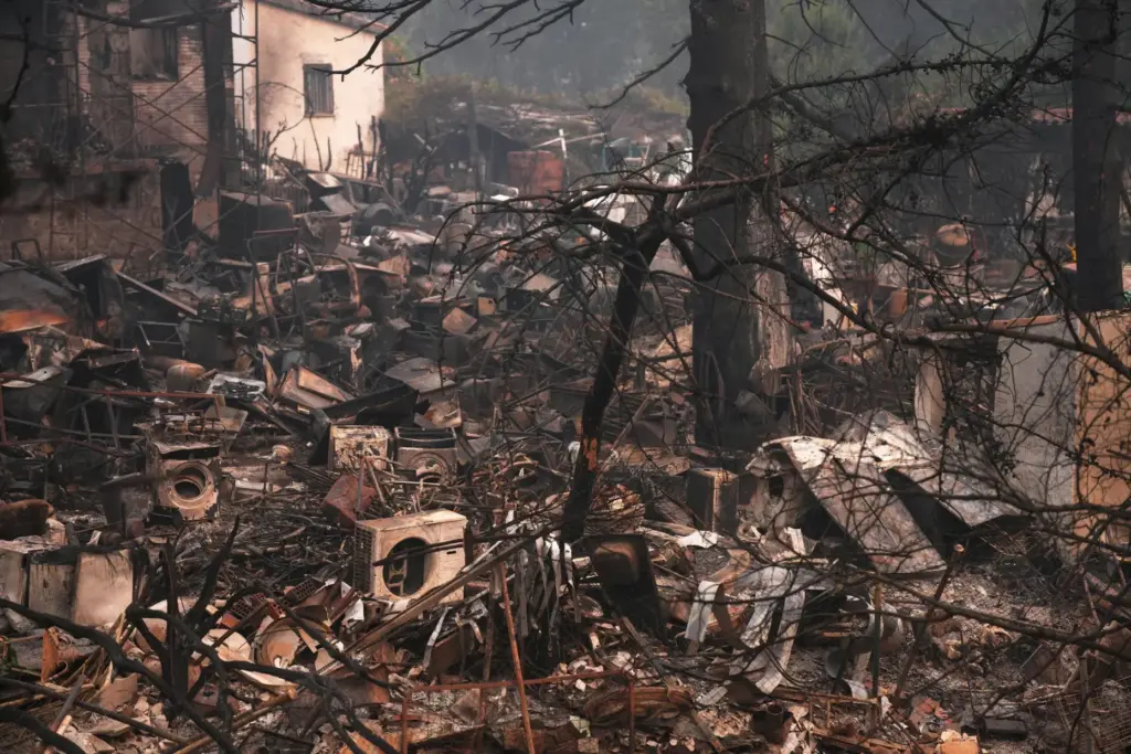 A house and belongings destroyed by a wildfire are photographed...
