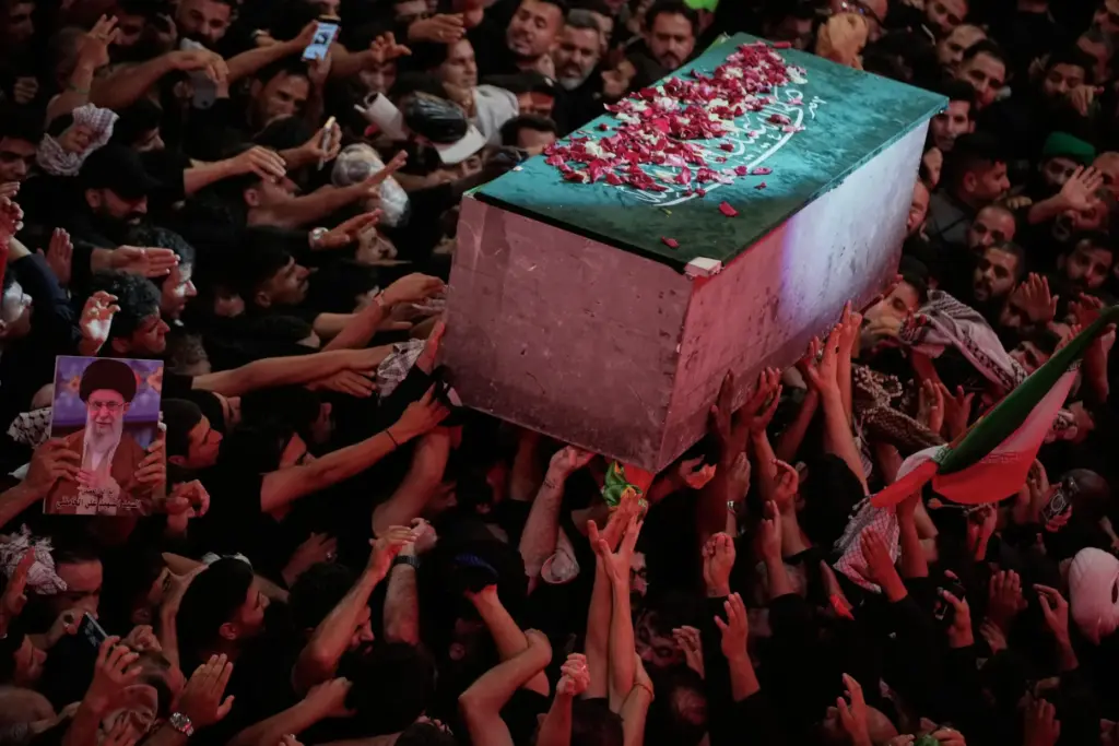 The flower petal-covered coffin of Iranian Supreme Leader Ayatollah Ali Khamenei is carried above mourners.