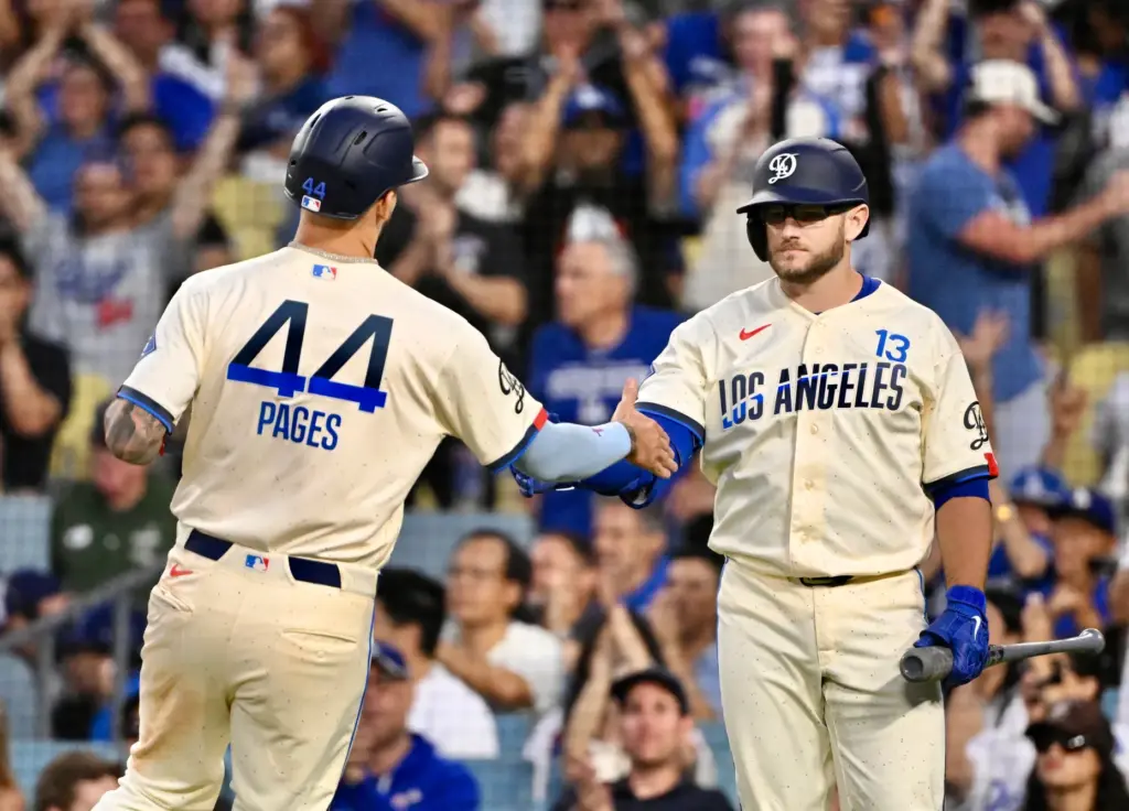 Andy Pages of the Dodgers high fives teammate Max Muncy...
