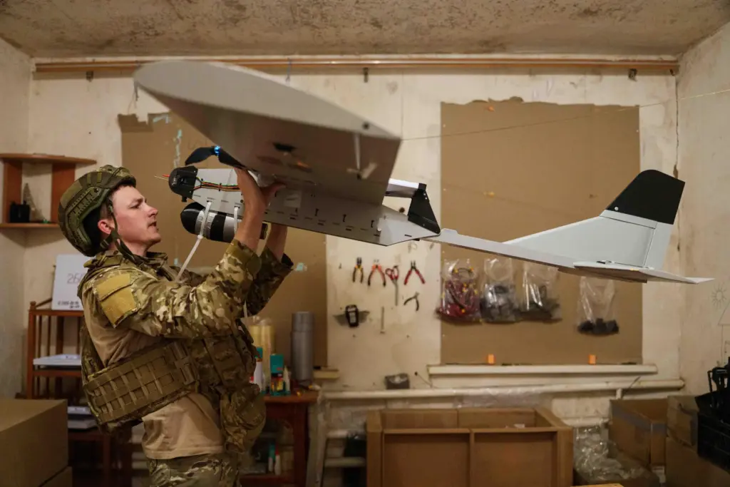 A serviceman with Ukraine’s K-2 brigade prepares a midrange drone...
