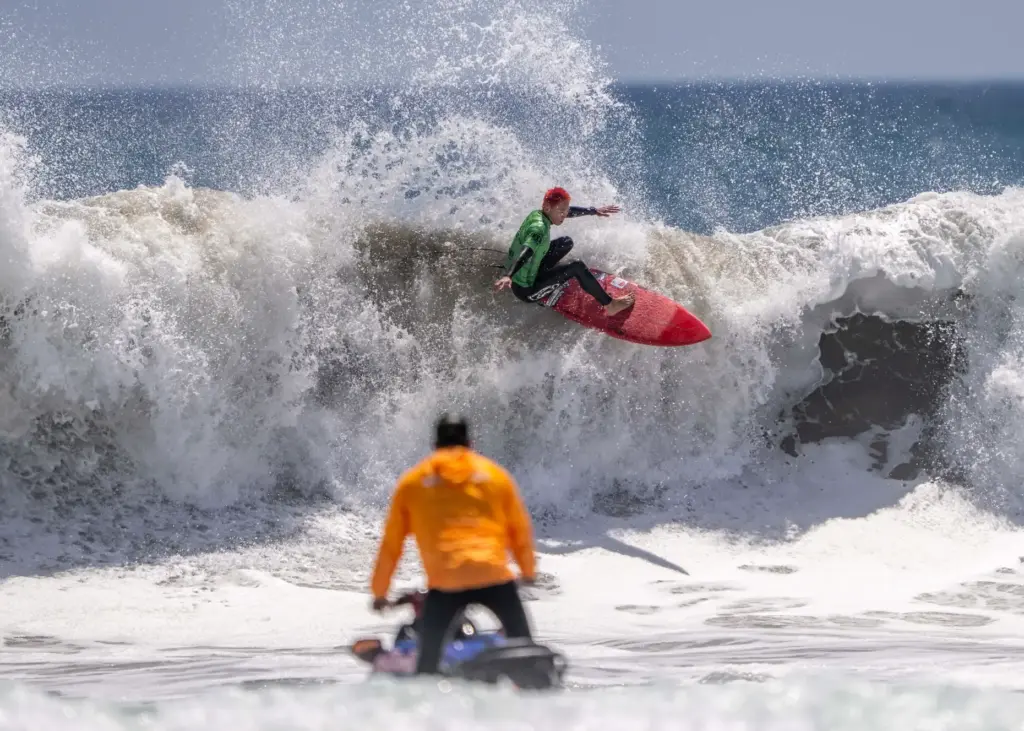 A wave runner waits to take Japanese surfer Keijiro Nishi,...