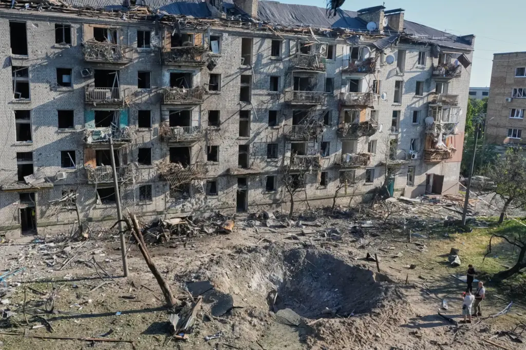 People look at the site of a Russian missile strike.
