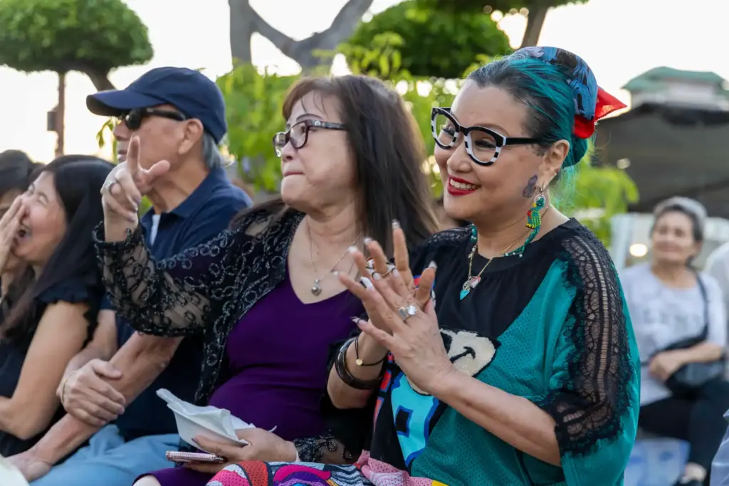 Kathy Vu (left) and Mama Mai dance and smile while...