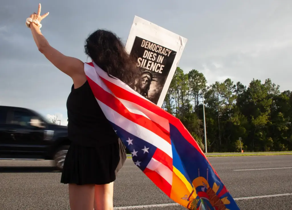 Patricia Ramos, of Palm Coast, wears a flag and waves...