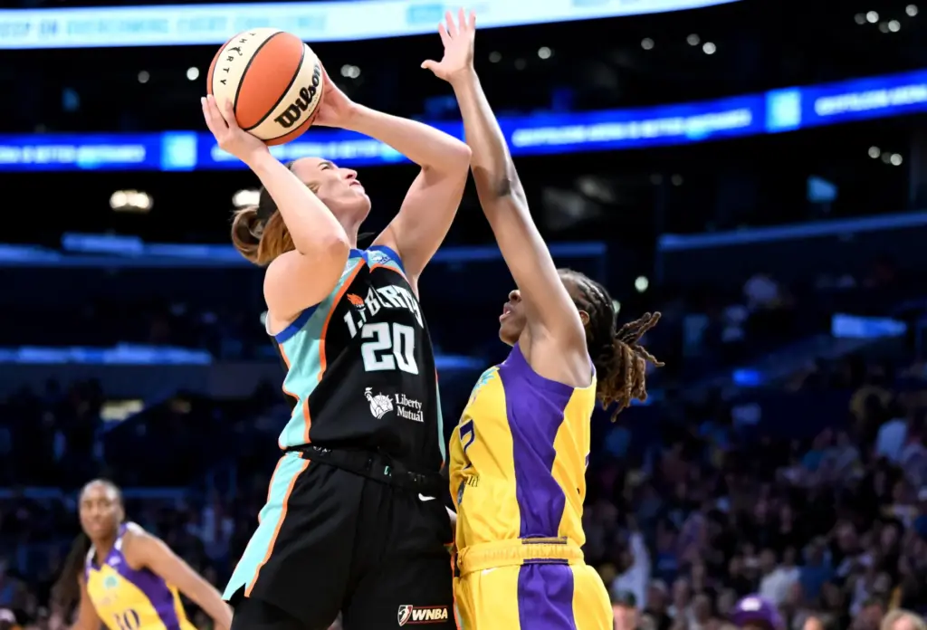New York Liberty guard Sabrina Ionescu, left, takes a shot...