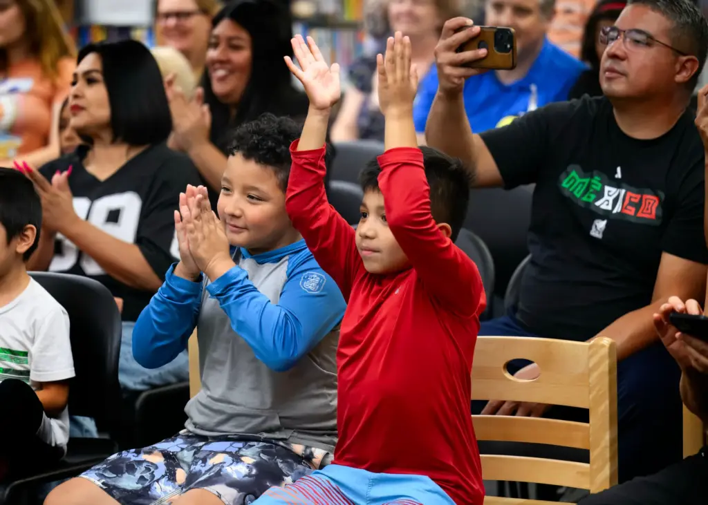 Levi Ocampo, 9, left, and his brother Eli, 7, applaud...