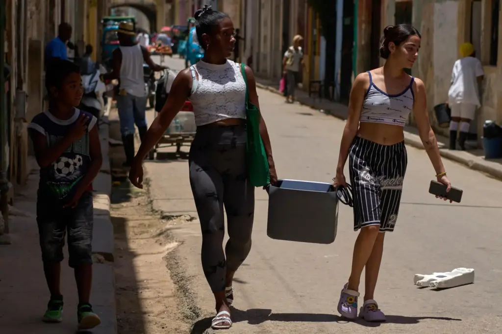 People carry a portable power charger during a blackout in...