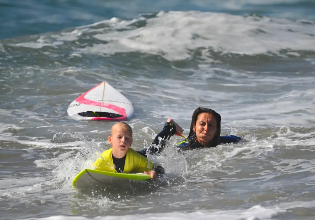 Pro surfer Ariane Ochoa works with Lindsey Martin, 6, during...