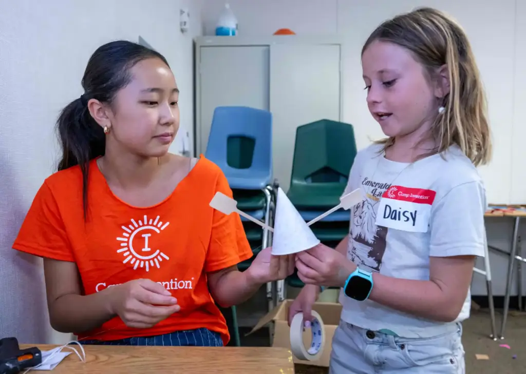 Camp Counselor Emma Lee, left, helps Daisy Butterfield, 9, with...