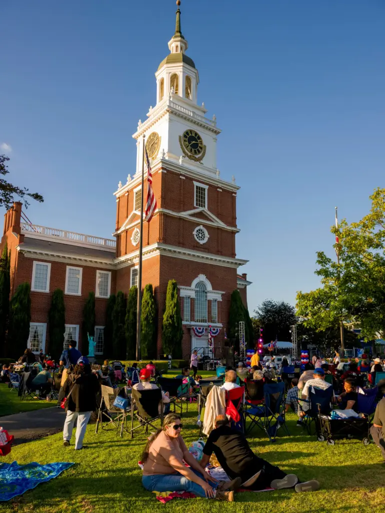 Families setup chairs and blankets on the lawn during the...