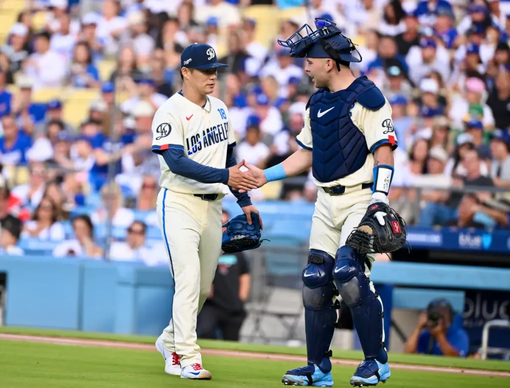 Starting pitcher Yoshinobu Yamamoto of the Dodgers shakes hands with...