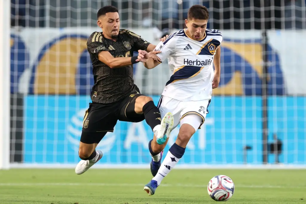 LAFC midfielder Mark Delgado, left, defends against Galaxy midfielder Lucas...