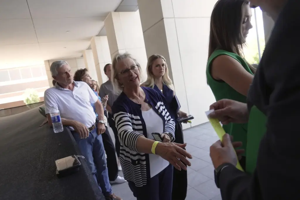 People receive wristbands to access limited public seating available at...
