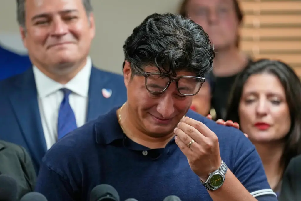 Ronaldo Salgado, son of Lorenzo Salgado Araujo, wipes away tears...