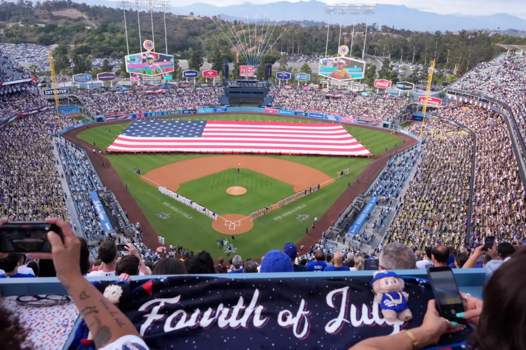 Fans watch during the national anthem prior to a baseball...