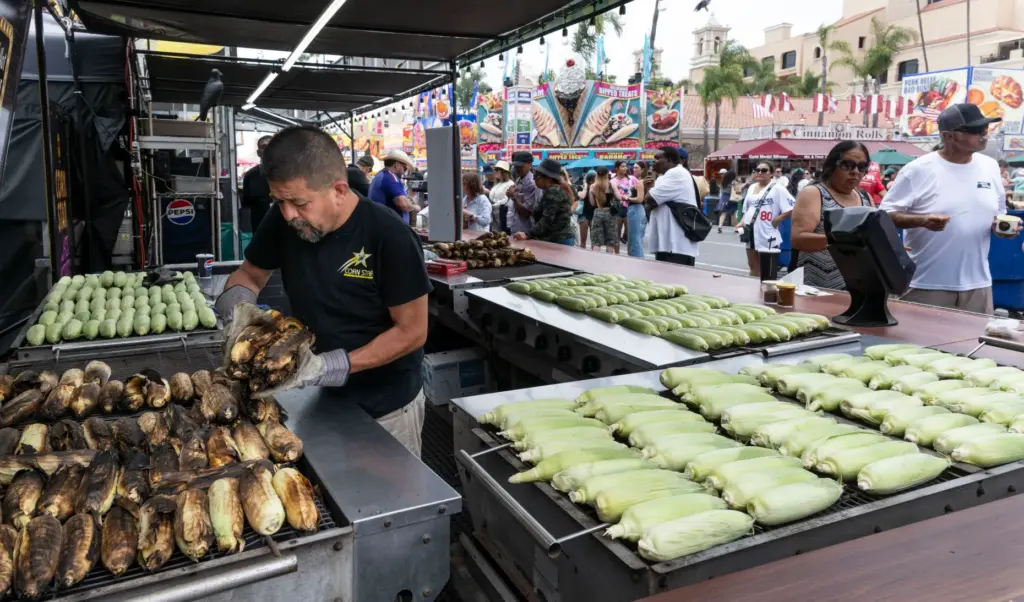 A worker cooks ears of corn at Corn Star &...