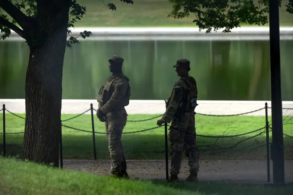 National Guard members stand near the Lincoln Memorial Reflecting Pool,...