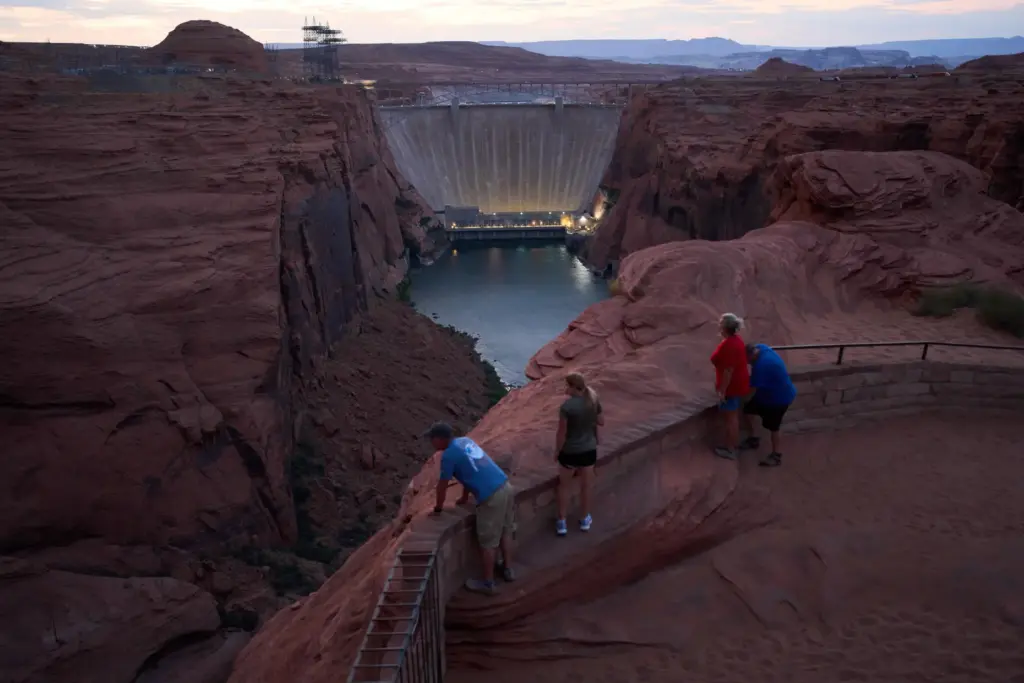 People view the Glen Canyon Dam from a viewpoint above...