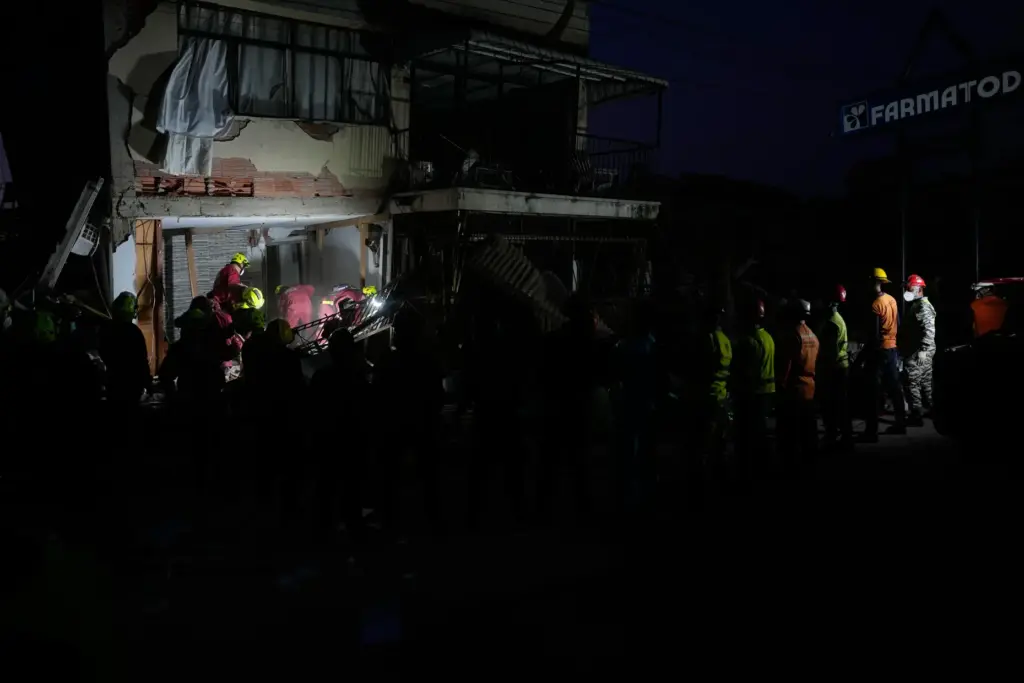 Rescuers from Argentina search a building damaged by back-to-back earthquakes...