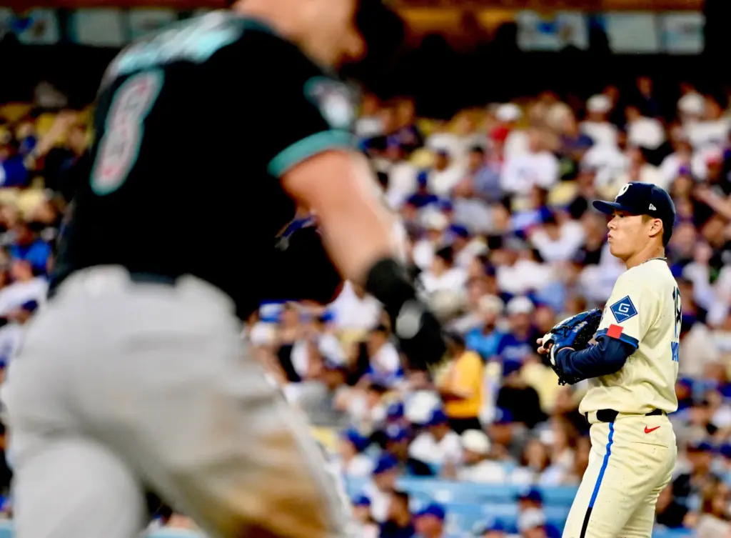 Starting pitcher Yoshinobu Yamamoto of the Dodgers looks on as...