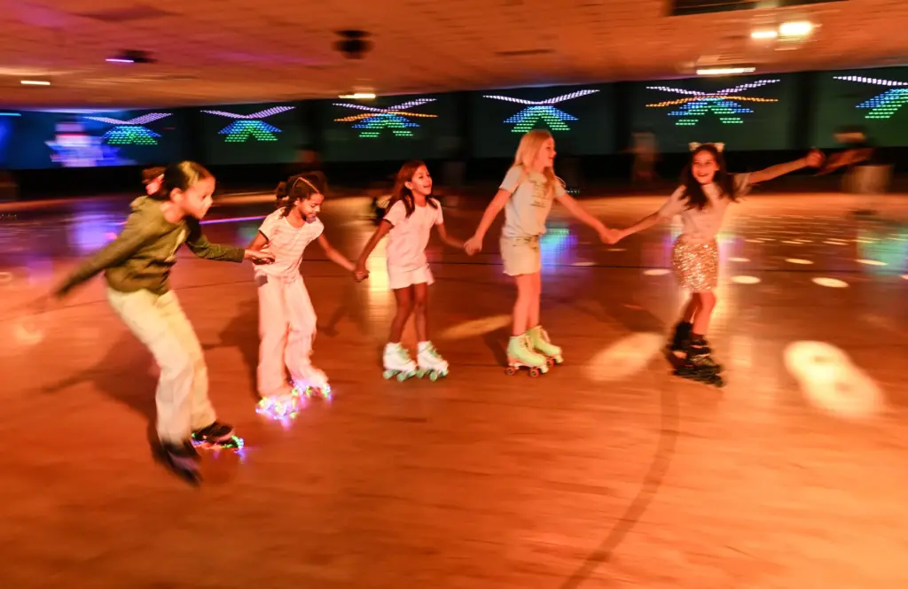 Skaters roll around the rink at Holiday Skate Center in...