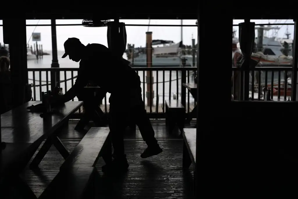 A Haitian worker with Temporary Protected Status cleans and busses...
