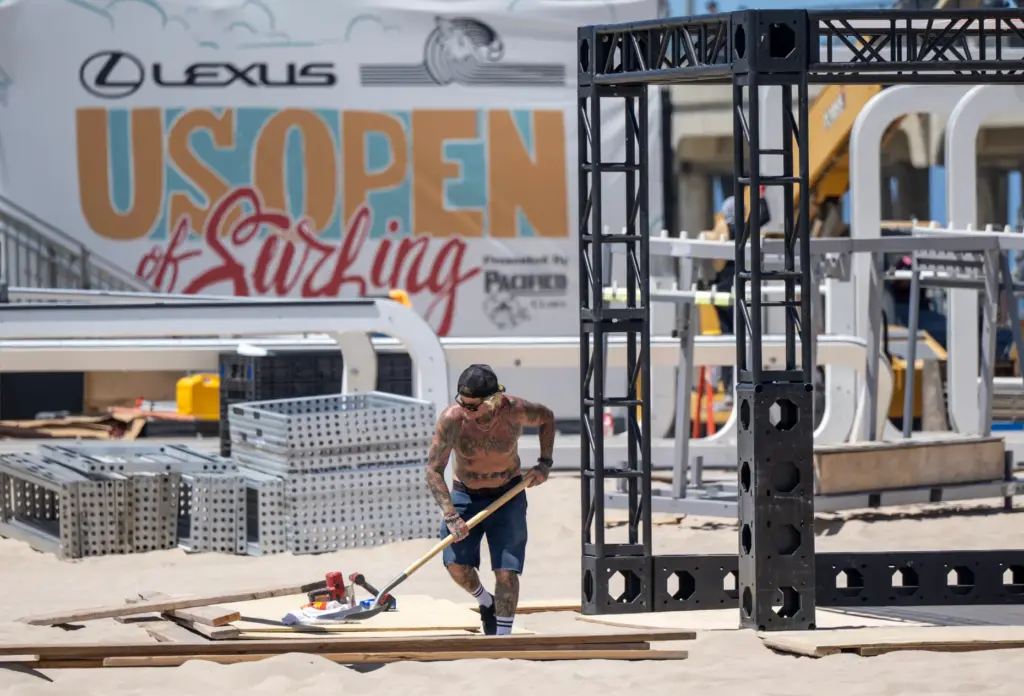 A worker shovels sand as he, and dozens of others,...