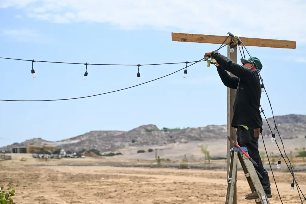 A ranch hand takes down lights at Shahnawaz Ranch in...