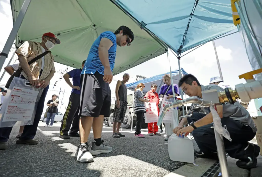 Residents receive water supplies at Hikawa town hall.