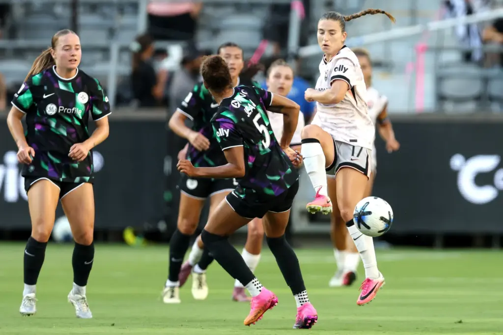 Angel City FC midfielder Ally Sentnor, right, kicks the ball...
