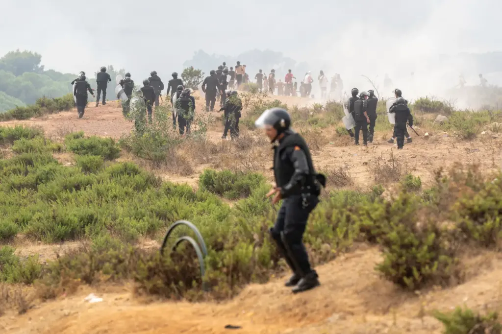 Members of Moroccan security forces disperse people attempting to cross into Ceuta.