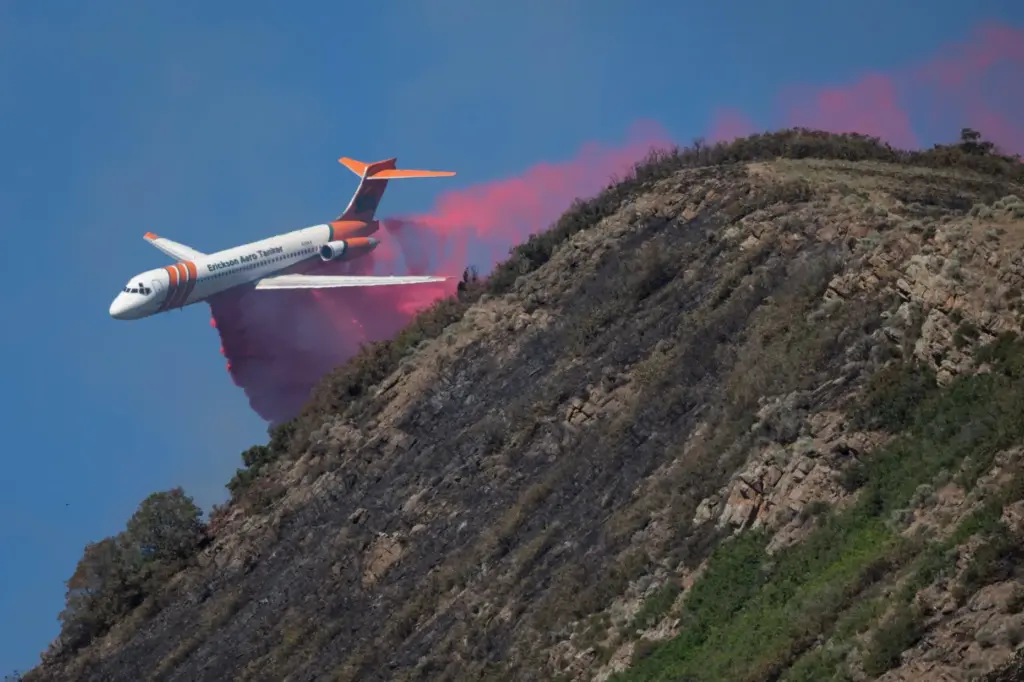 An Erickson Aero Tanker drops fire retardants on a wildfire...