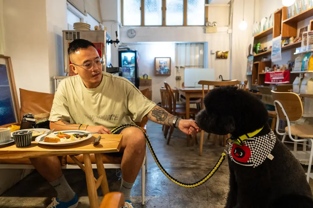 A customer feeds his dog inside the Wan Land Cafe...