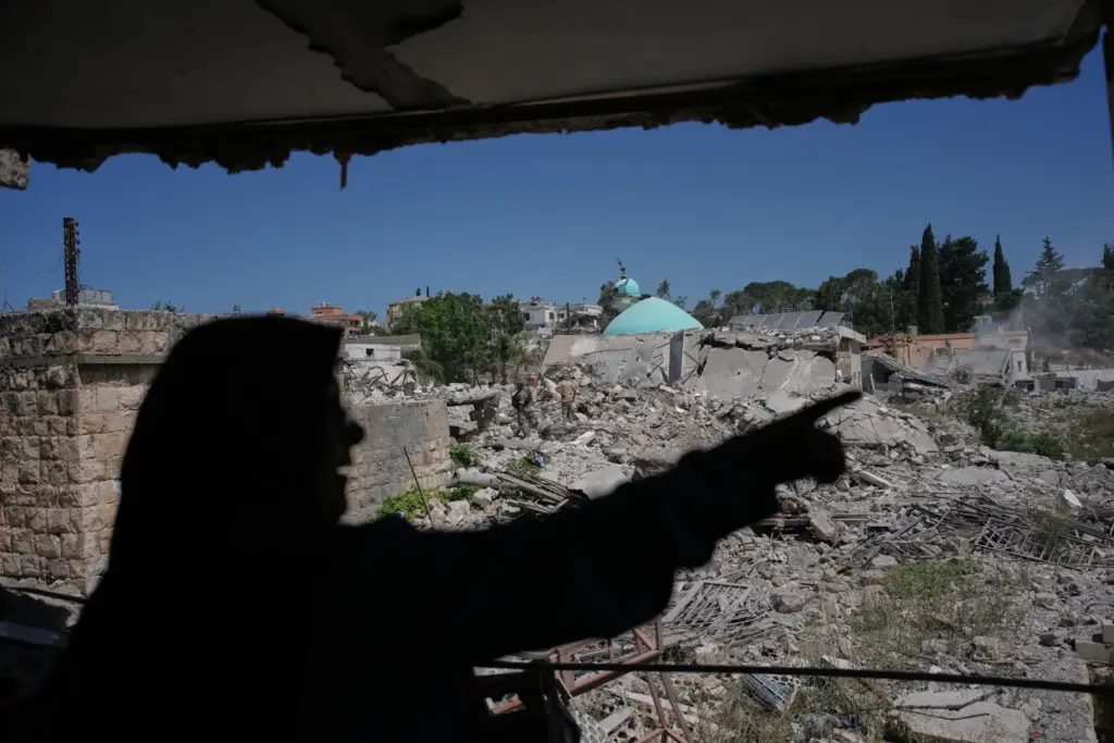 Mahasen Faqih gestures toward the rubble of her neighborhood.