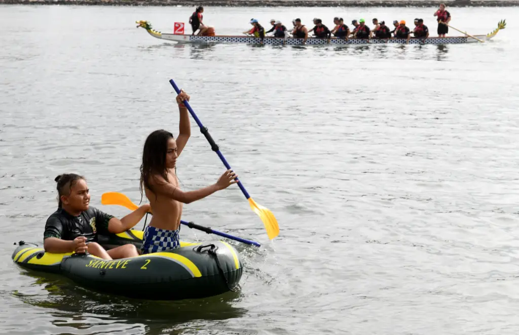 Brothers Jace, 9, and Vai Ueligitoue, 8, paddle their rubber...