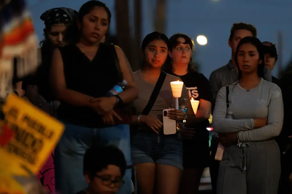 Mourners hold candles during a vigil for Lorenzo Salgado Araujo,...
